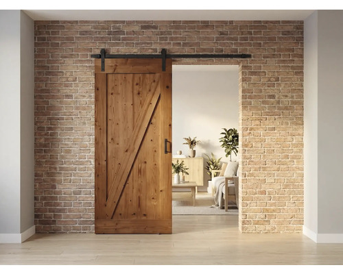 Holzschiebetür mit Beschlägen vor einer Backsteinwand