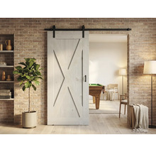 Holzschiebetür im Scheunenstil mit Beschlägen vor Ziegelwand