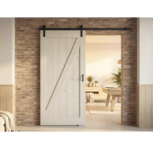 Holzschiebetür im Landhausstil mit Beschlägen vor einer Ziegelwand