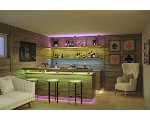 Modern gestaltete Hausbar mit Holzpaneelen, beleuchteter Theke, Barhockern, einem Sofa und einem Sessel in einem gemütlich eingerichteten Raum.