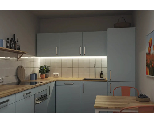 Moderne Einbauküche in L-Form mit hellblauen Fronten, Arbeitsplatte aus Holz und weißem Fliesenspiegel. Inklusive Backofen und Spüle.