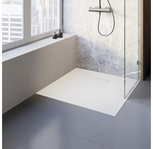 Ebenerdige Dusche mit Glasabtrennung und Duscharmatur vor einer Marmorwand