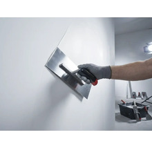 Hand mit Putzglätter beim Glätten einer Wand