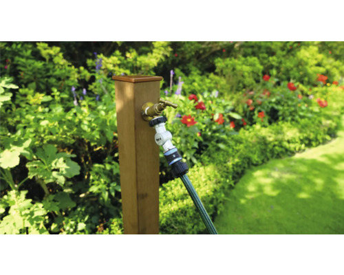 Gartenszene mit Wasserhahn und Gartenschlauch an einem Holzpfosten