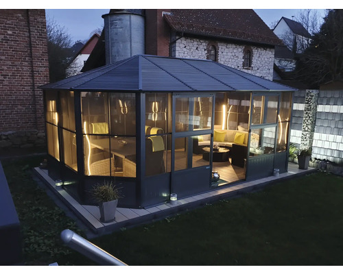 Außenansicht eines Pavillons mit Möbeln im Garten.