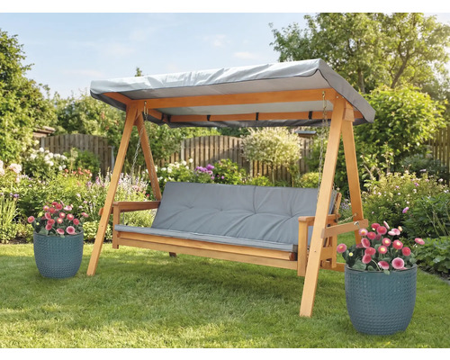 Holzschaukel mit grauen Auflagen und Dach im Garten