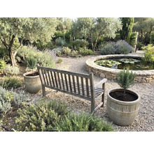 Gartenszene mit Holzbank, Pflanzenkübeln und Teich