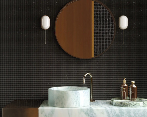 Modernes Badezimmer mit dunklen Fliesen, rundem Spiegel und Marmorwaschbecken