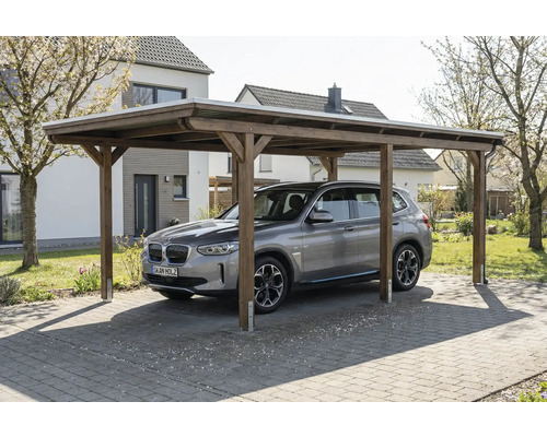 Ein Auto steht unter einem Holzcarport im Freien.