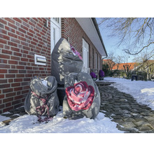 Winterlandschaft mit Pflanzen in Schutzhüllen vor einem Backsteinhaus