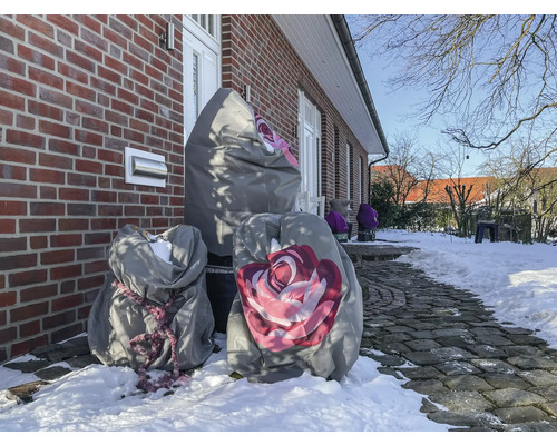 Winterlandschaft mit Pflanzen in Schutzhüllen vor einem Backsteinhaus