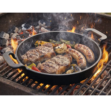 Grillpfanne mit Steaks, Würstchen und Gemüse auf dem Grill