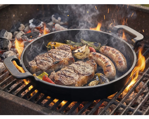 Grillpfanne mit Steaks, Würstchen und Gemüse auf dem Grill