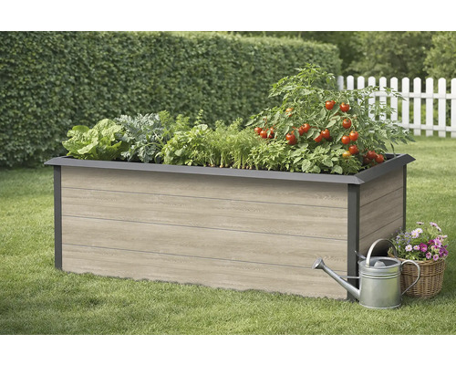 Hochbeet aus Holz mit verschiedenen Gemüsesorten, Gießkanne und Korb mit Blumen im Garten