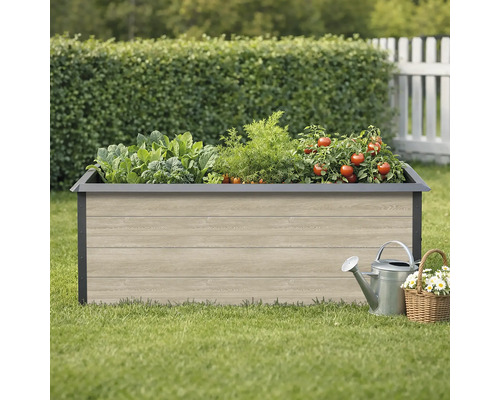 Hochbeet mit Gemüse, Gießkanne und Blumenkorb im Garten