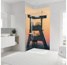 Duschrückwand mit industriellem Motiv eines Fördergerüsts vor einem Abendhimmel in einem hellen Badezimmer.