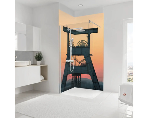 Duschrückwand mit industriellem Motiv eines Fördergerüsts vor einem Abendhimmel in einem hellen Badezimmer.