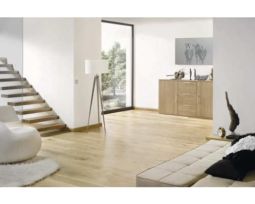 Hell gestalteter, geräumiger Wohnbereich mit modernem Bodenbelag in Holzoptik, einer freischwebenden Treppe und einem Sideboard.