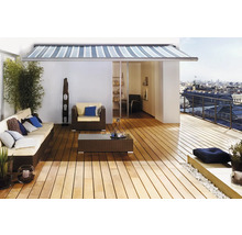 Gestreifte Markise über einer Dachterrasse mit Holzdeck, Polyrattan-Loungemöbeln und Stadtblick.