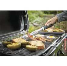 Grill mit Grillgut wie Speck, Eiern, Brot und Avocado, das mit einer Zange gewendet wird.