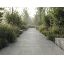 Gartenweg mit quadratischen Pflastersteinen und Bänken