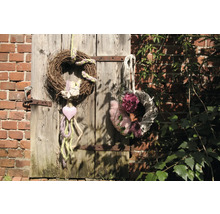 Dekorative Kränze aus Naturmaterialien an einer Holztür