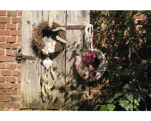 Dekorative Kränze aus Naturmaterialien an einer Holztür