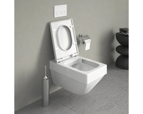 Wandhängendes WC mit offenem Toilettendeckel, Spülknopf, Toilettenbürste und Toilettenpapierhalter in Badezimmer.