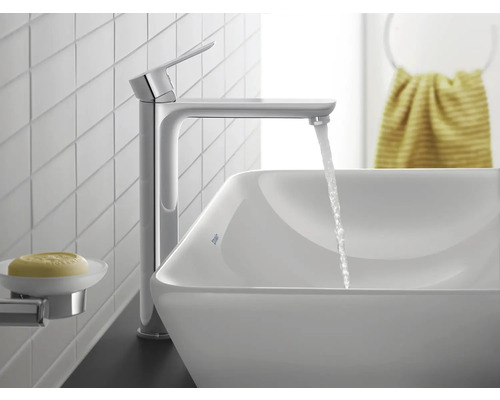 Moderne Waschtischarmatur in Chrom mit hohem Auslauf und Einhebelmischer, fließendes Wasser in ein weißes Aufsatzwaschbecken.