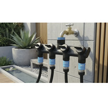 Gartenszene mit einem Mehrfachverteiler von for.q am Wasserhahn