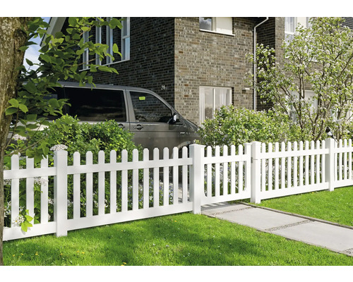 Weißer Lattenzaun mit Tor im Garten