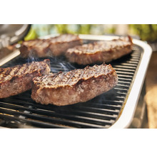Auf einem Grill liegen Steaks.