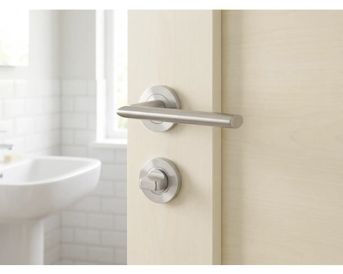 Tür mit Türbeschlag und Badezimmer im Hintergrund