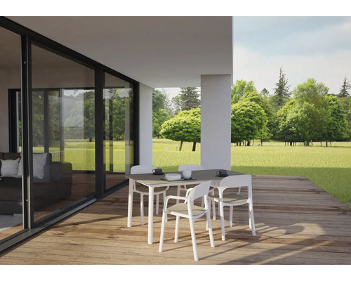 Essgruppe mit Tisch und Stühlen auf einer Terrasse mit Blick ins Grüne