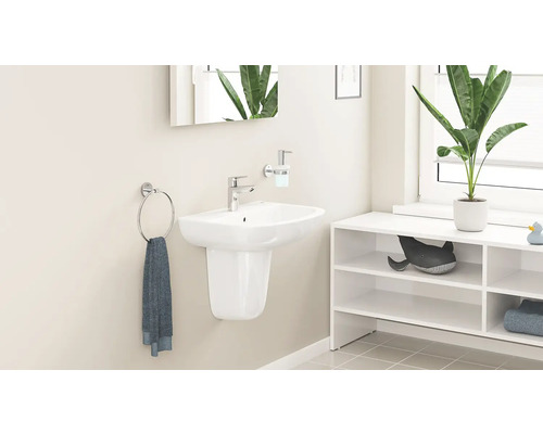 Modernes Badezimmer mit weißem Wand-Waschbecken mit Halbsäule, verchromter Armatur, Seifenspender, Handtuchring und weißem Regal.