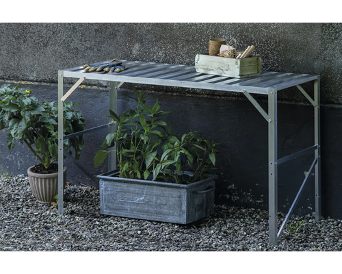 Pflanztisch aus Aluminium mit Lamellenoberfläche im Garten, darunter ein Pflanzkübel und daneben ein Blumentopf.