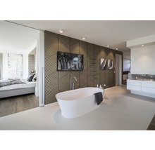 Modernes helles Badezimmer mit freistehender Badewanne, Wandverkleidung aus geometrischen Holzlamellen und Blick ins Schlafzimmer.