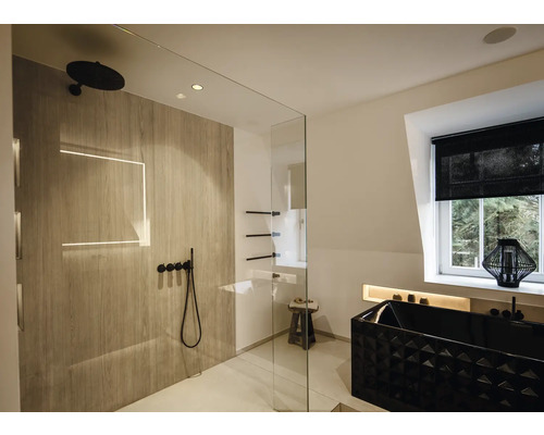 Modernes Badezimmer mit begehbarer Dusche in Holzoptik, schwarzen Armaturen und einer schwarzen Badewanne mit Struktur in hellem Raum.