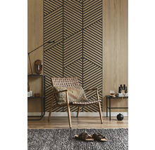 Wandpaneel mit geometrischem Lamellenmuster in Holzoptik hinter einem Sessel im modern gestalteten Wohnzimmer mit Holzboden.