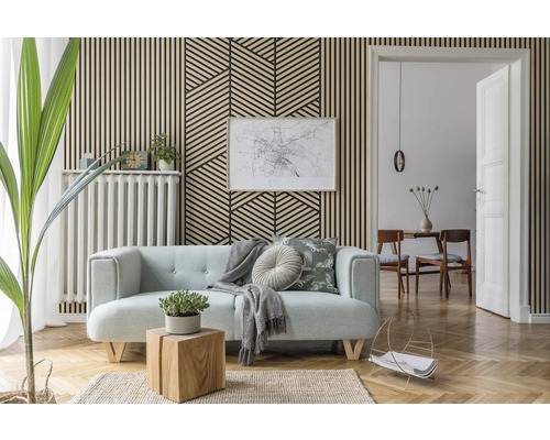 Wohnzimmer mit Akustikpaneelen in Holzoptik an der Wand, kombiniert mit einem geometrischen Muster, Sofa und Parkettboden.