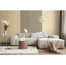 Modernes Wohnzimmer mit hellen Wandpaneelen in Holzoptik und vertikalen schwarzen Leisten hinter einem grauen Ecksofa.