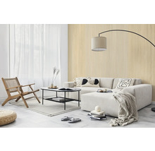 Hell gestaltetes Wohnzimmer mit Wandpaneelen in Holzoptik und Lamellenstruktur, hellem Sofa, schwarzem Couchtisch und Holz-Loungesessel.