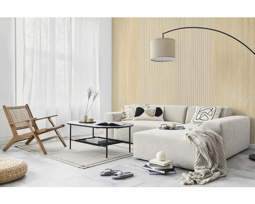 Hell gestaltetes Wohnzimmer mit Wandpaneelen in Holzoptik und Lamellenstruktur, hellem Sofa, schwarzem Couchtisch und Holz-Loungesessel.