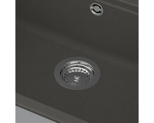 Nahaufnahme eines Spülbeckenabflusses mit Siebkörbchen und Überlauf in einer Verbundspüle.