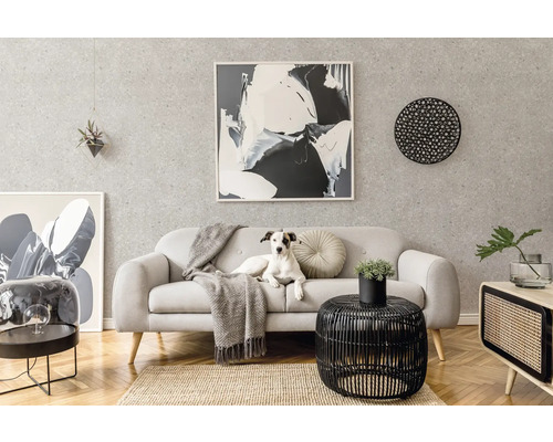 Modernes Wohnzimmer mit hellem Sofa, grauer Strukturtapete, abstrakter Kunst, schwarzem Beistelltisch und Sideboard auf Fischgrätparkett.