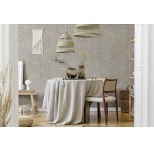 Modernes Esszimmer mit Terrazzo-Tapete, einem runden Tisch mit Leinentuch, geflochtenen Pendelleuchten und hellen Möbeln aus Naturmaterialien.