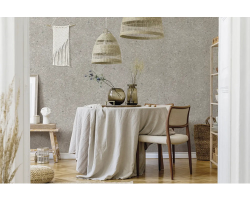 Modernes Esszimmer mit Terrazzo-Tapete, einem runden Tisch mit Leinentuch, geflochtenen Pendelleuchten und hellen Möbeln aus Naturmaterialien.