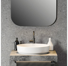 Modernes Badezimmer mit rundem weißem Aufsatzwaschbecken, schwarzer Armatur, Wand in Terrazzo-Optik und Spiegel mit abgerundeten Ecken.