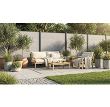 Modernes Garten-Lounge-Set aus Holz auf einer hellen Fliesenterrasse mit Sichtschutzzaun, Olivenbäumen und Gräsern in Töpfen.