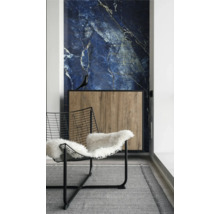 Innenraum mit blauer Marmor-Wandverkleidung, Holz-Sideboard mit schwarzem Rahmen und Drahtstuhl mit weißem Fell auf grauem Teppich.